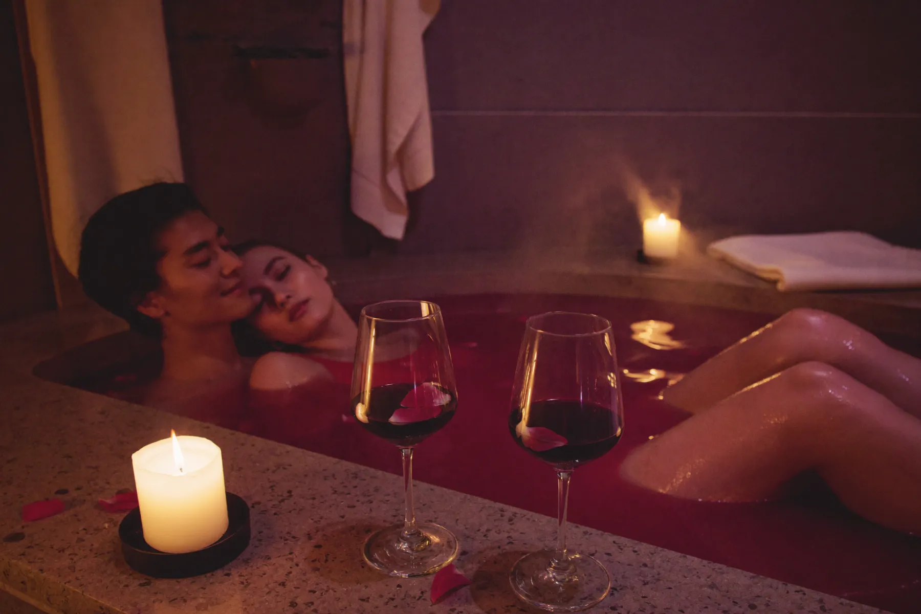 Couple partageant un bain de vin dans un spa aux chandelles