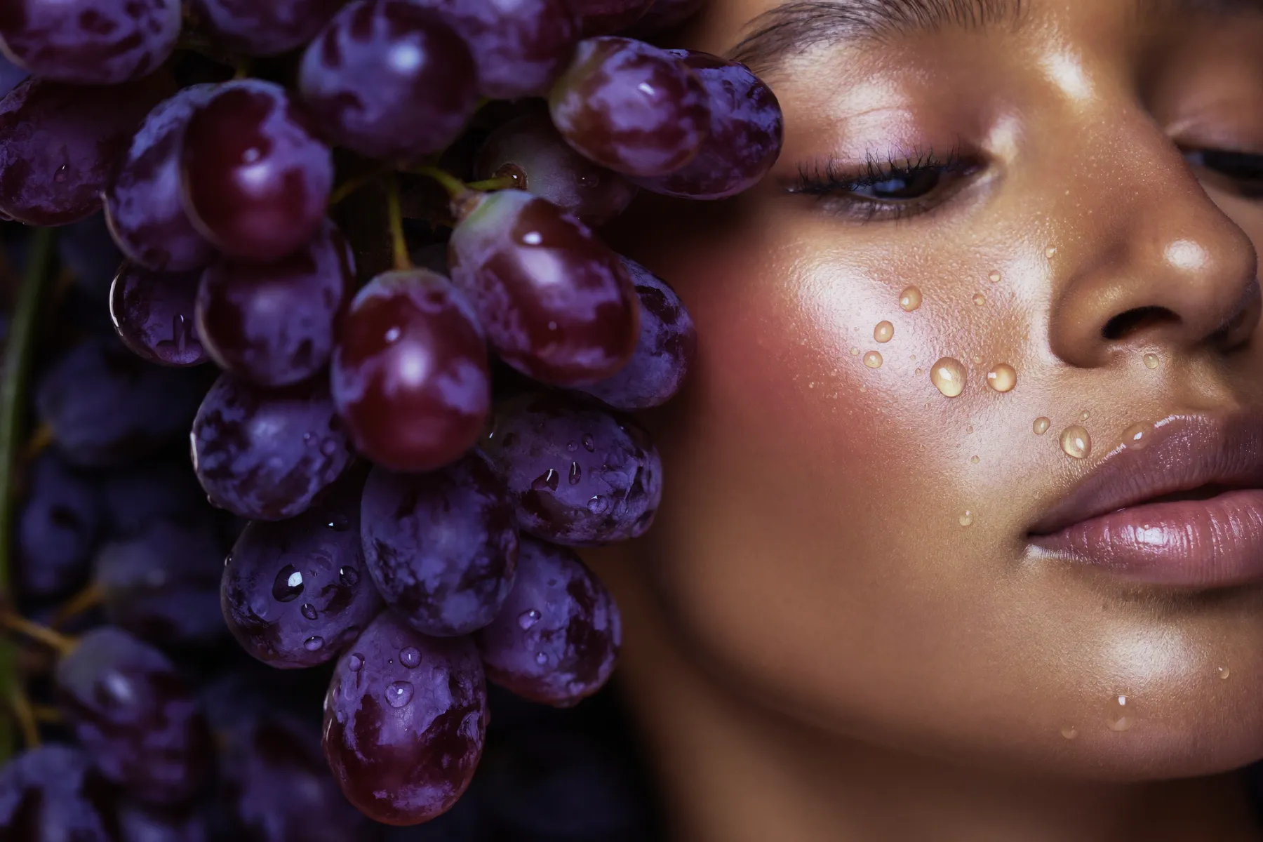 Gros plan de raisins rouges perlés d'eau près d'une peau lumineuse